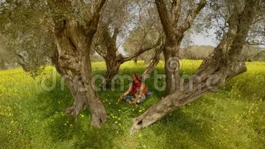 一个戴着红领巾和戴着黑眼镜的女孩正坐在一个橄榄园的中央，上面长满了黄花绿草